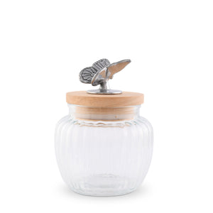 Glass canister with a wooden lid and butterfly detail, viewed at an angle, showcases artisanal craftsmanship for kitchen decor.