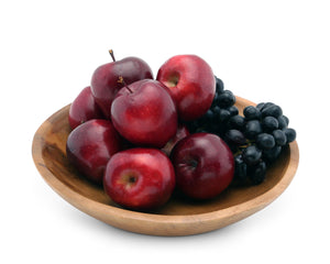 A wooden salad bowl filled with red apples and grapes, viewed from a slight angle, highlighting its artisanal craftsmanship.