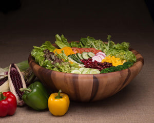 A wooden salad bowl in a side view, filled with colorful vegetables, ideal for modern classic table settings.