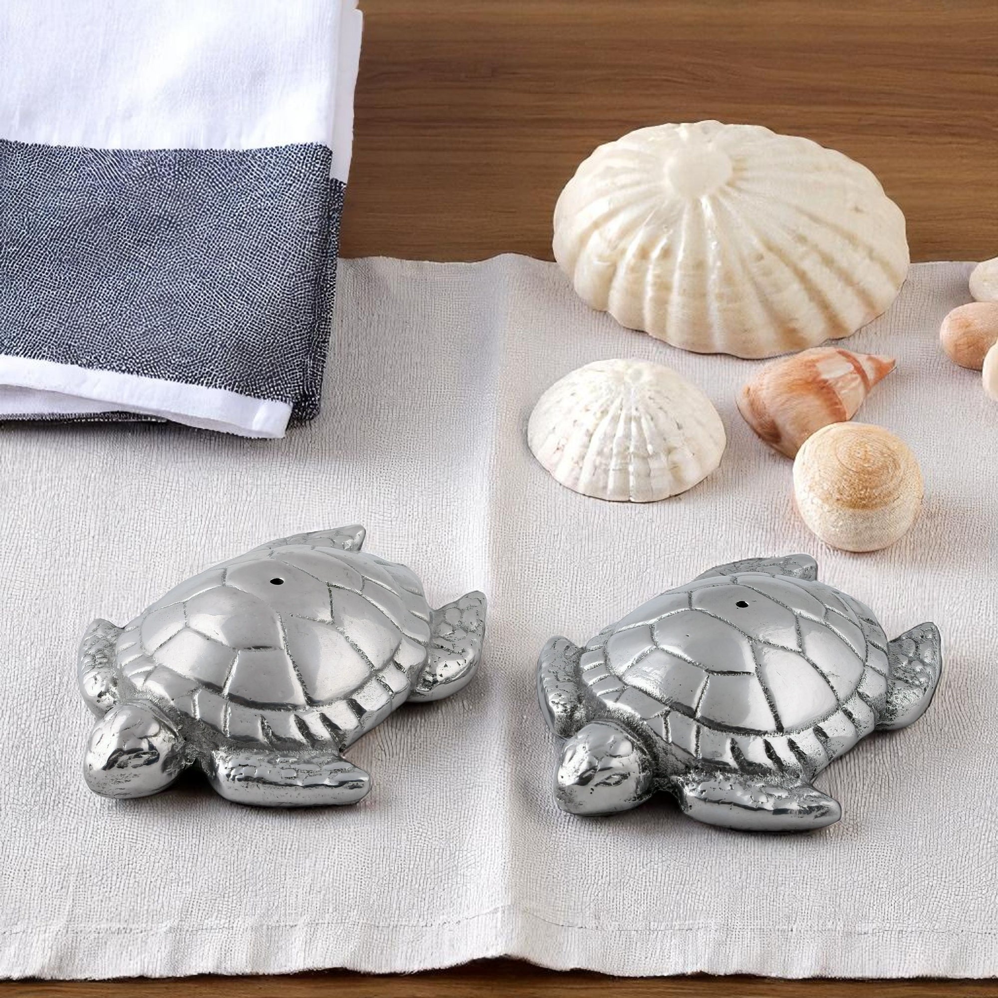 Salt and pepper shakers shaped like turtles viewed from above, showcasing artisanal craftsmanship and coastal decor appeal.