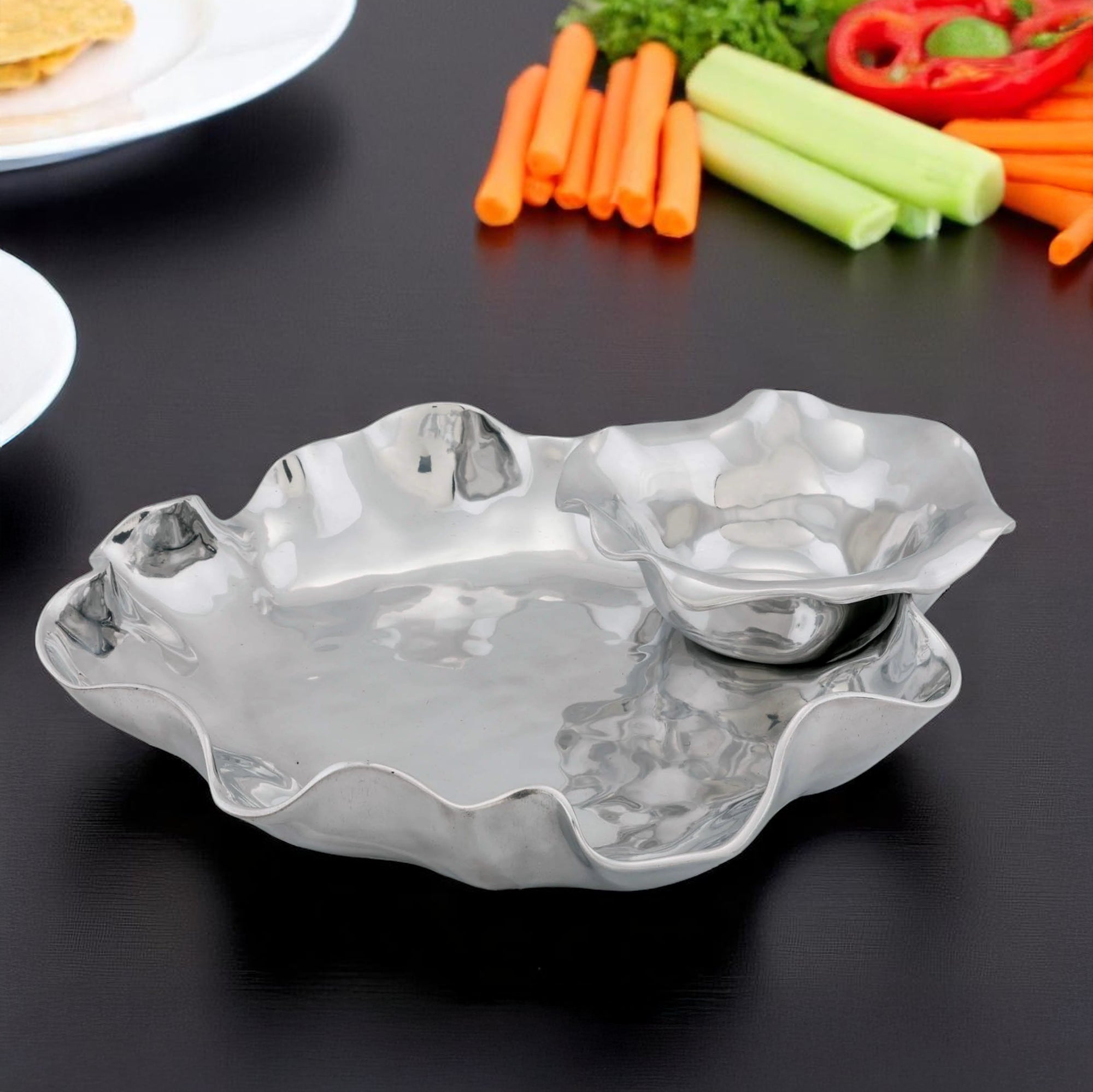 A Chip Dip Set with wavy, metallic bowls viewed from a slight angle, showcasing designer tableware appeal.