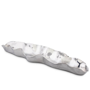 A silver bread tray, seen at an angle, showcasing its wavy edges and reflective surface, ideal for modern classic decor.