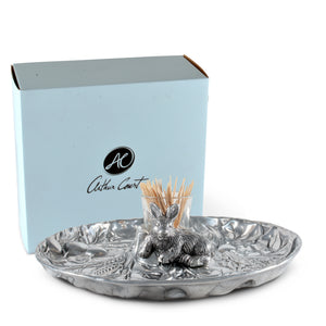 Arthur Court catch-all dish with intricate rabbit motif, viewed from a slight side angle, staged beside stylish packaging