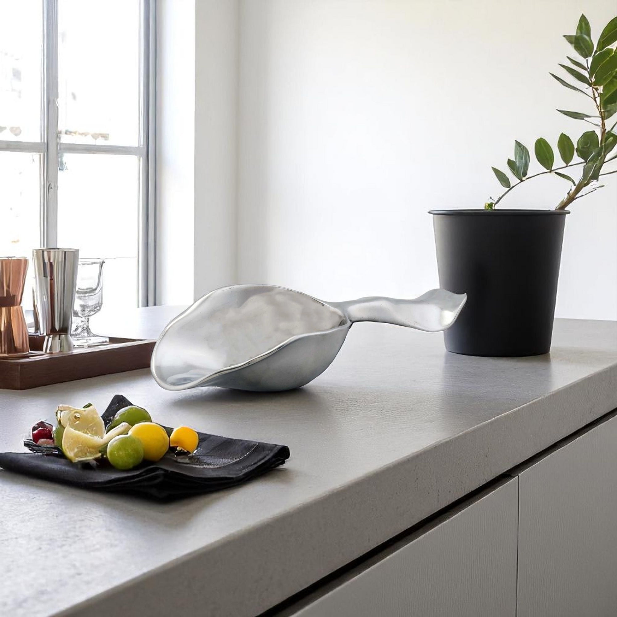 A sleek ice scoop with artisanal craftsmanship, angled to highlight its modern design against a white background.