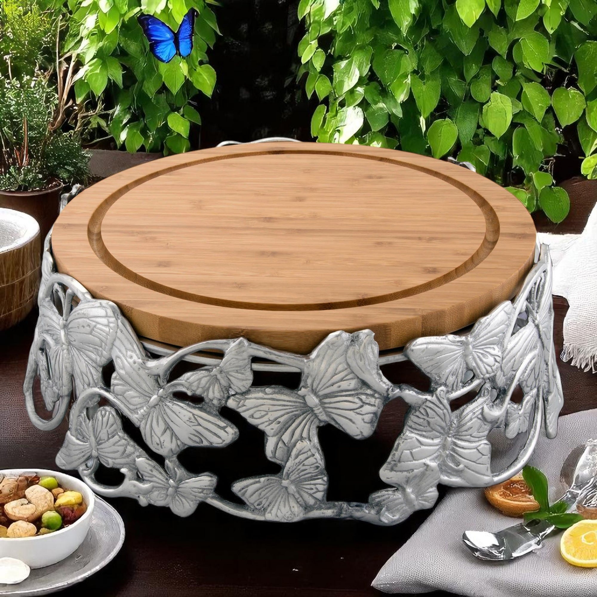 Round cheese board with intricate butterfly metalwork viewed from a side angle, highlighting artisanal craftsmanship, perfect for entertaining essentials.