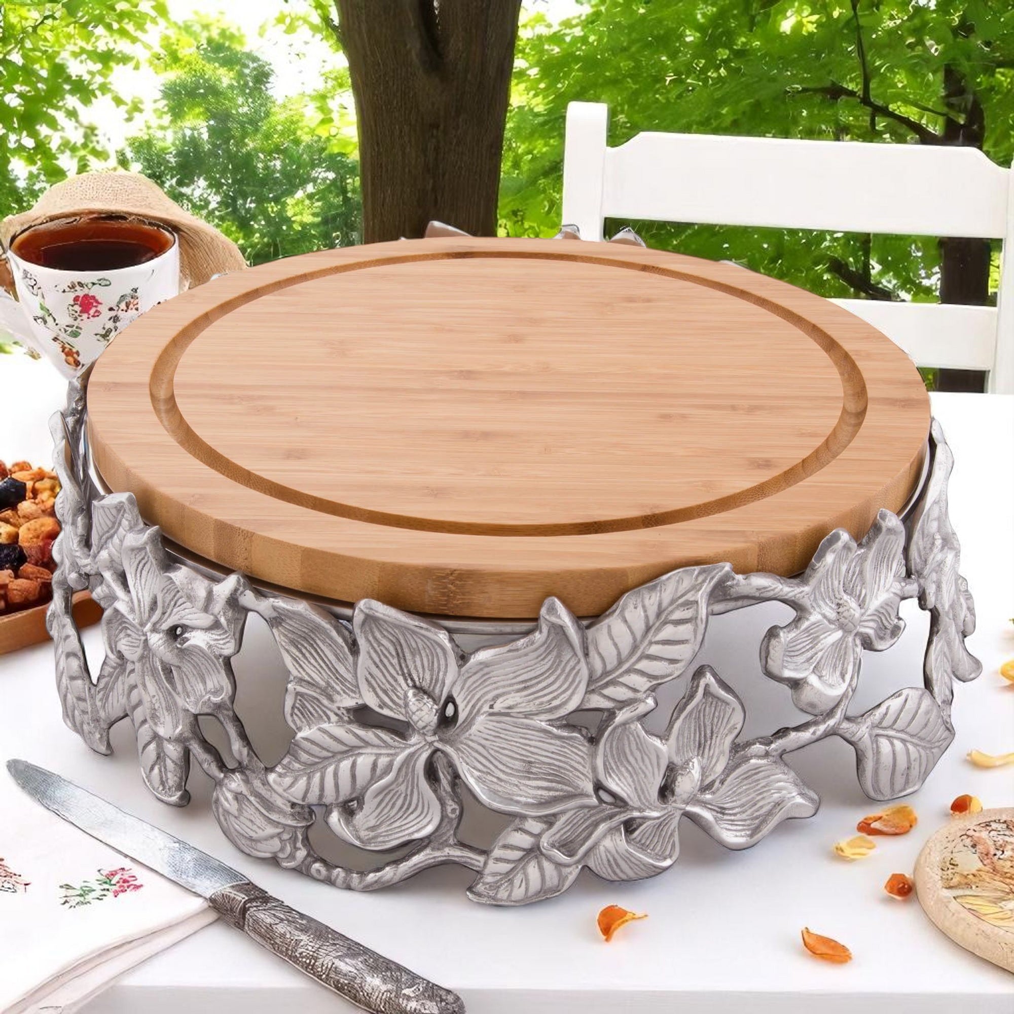 A bamboo cheese board with intricate floral metalwork viewed from the side, a perfect luxury home accessory.