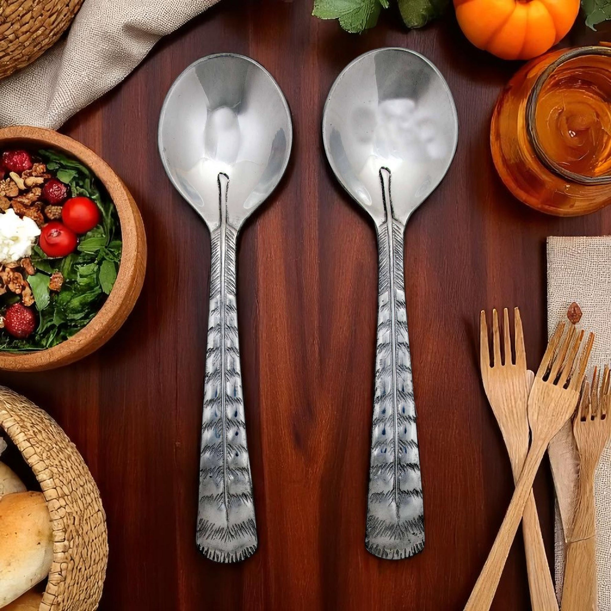In this image, two elegant salad serving spoons are viewed from above, showcasing artisanal craftsmanship and timeless design.
