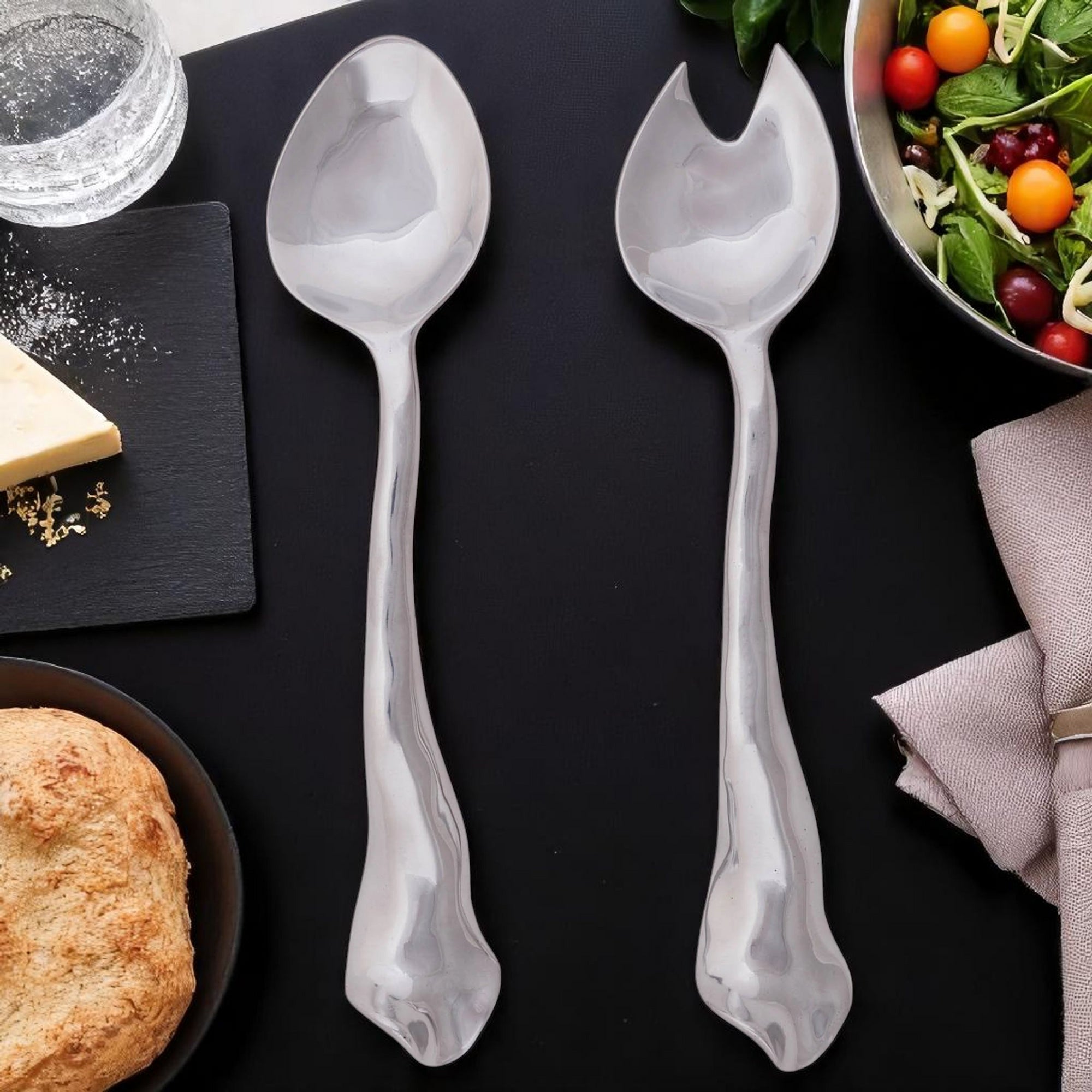 Artisanal metal salad serving set shown from above, highlighting elegant craftsmanship and modern classic design.