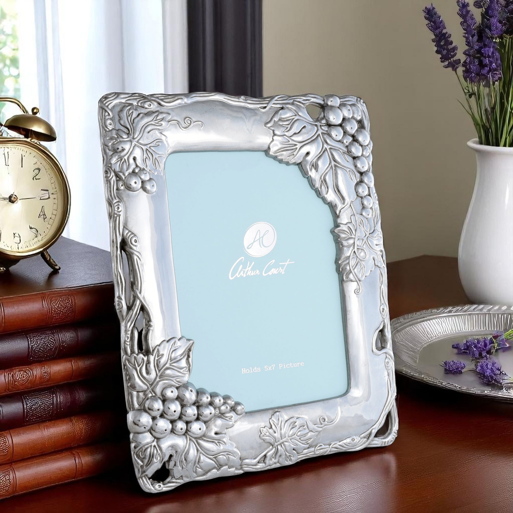 In a side-angled view, the Arthur Court photo frame showcases intricate grape and leaf details, a luxury home accessory.