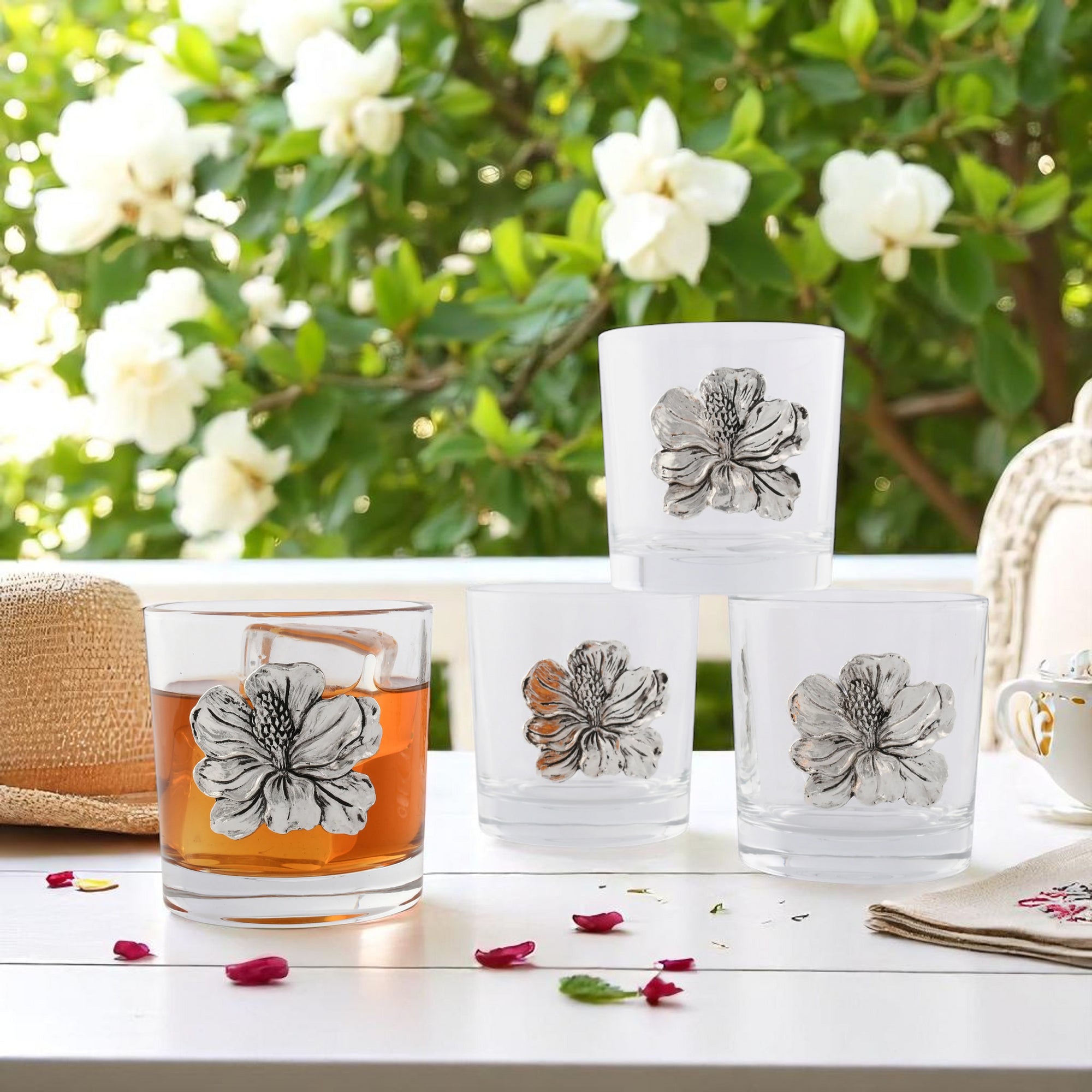 Bar glasses adorned with floral motifs, arranged in a creative stack, angled from the front highlighting their decorative charm