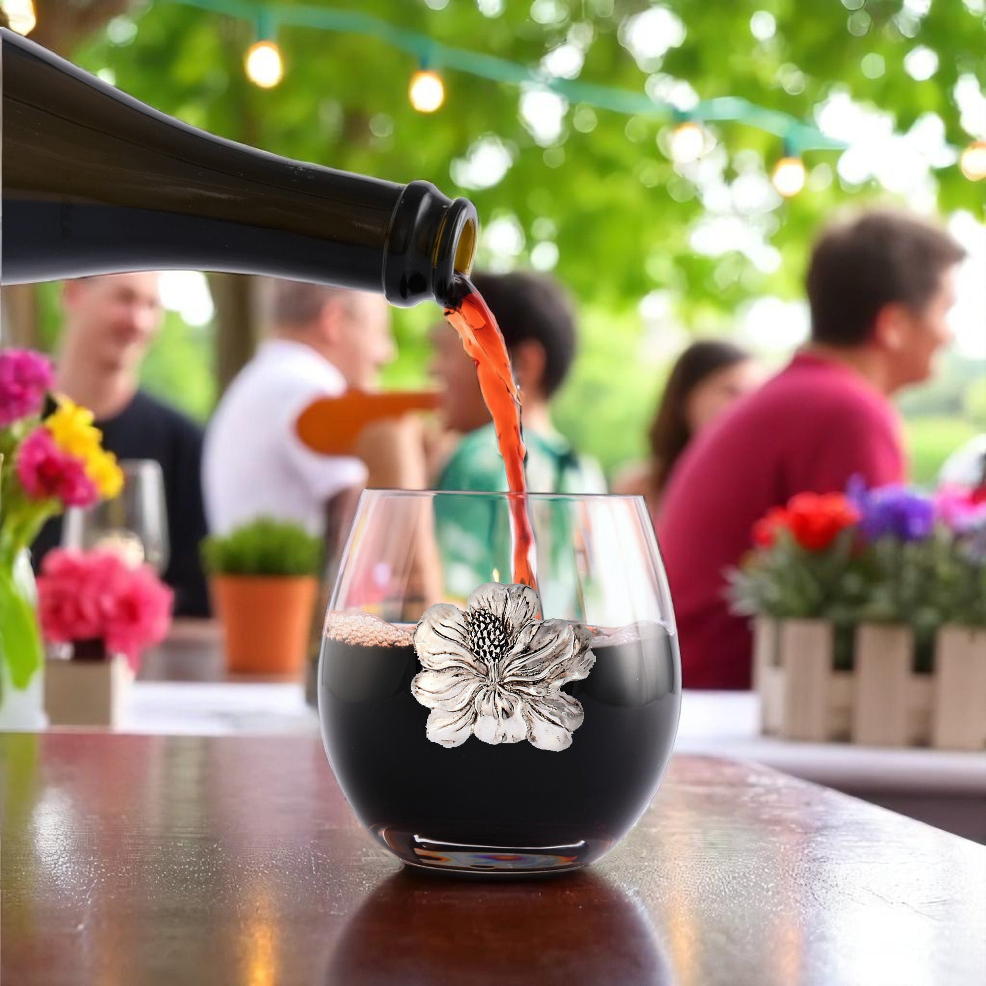 Red wine elegantly pours into a decorative glass adorned with floral motifs, angled to highlight the design.