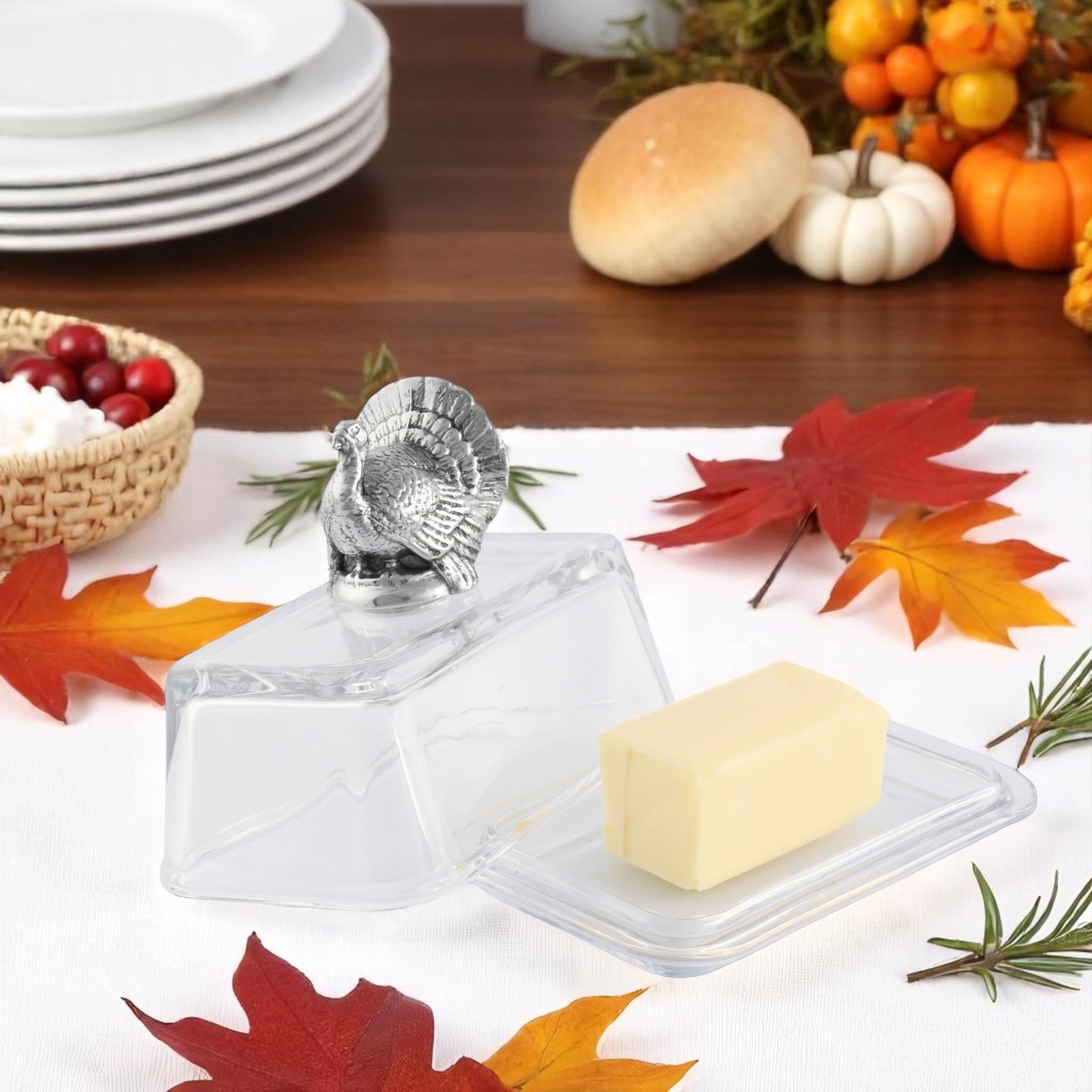A decorative butter dish with a turkey-shaped handle, viewed from an angled perspective showcasing its elegant design.