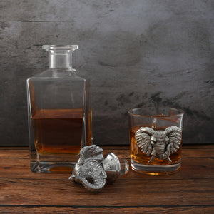 A liquor decanter with intricate stopper detail viewed from the side, showcasing artisanal craftsmanship on a rustic wooden table.