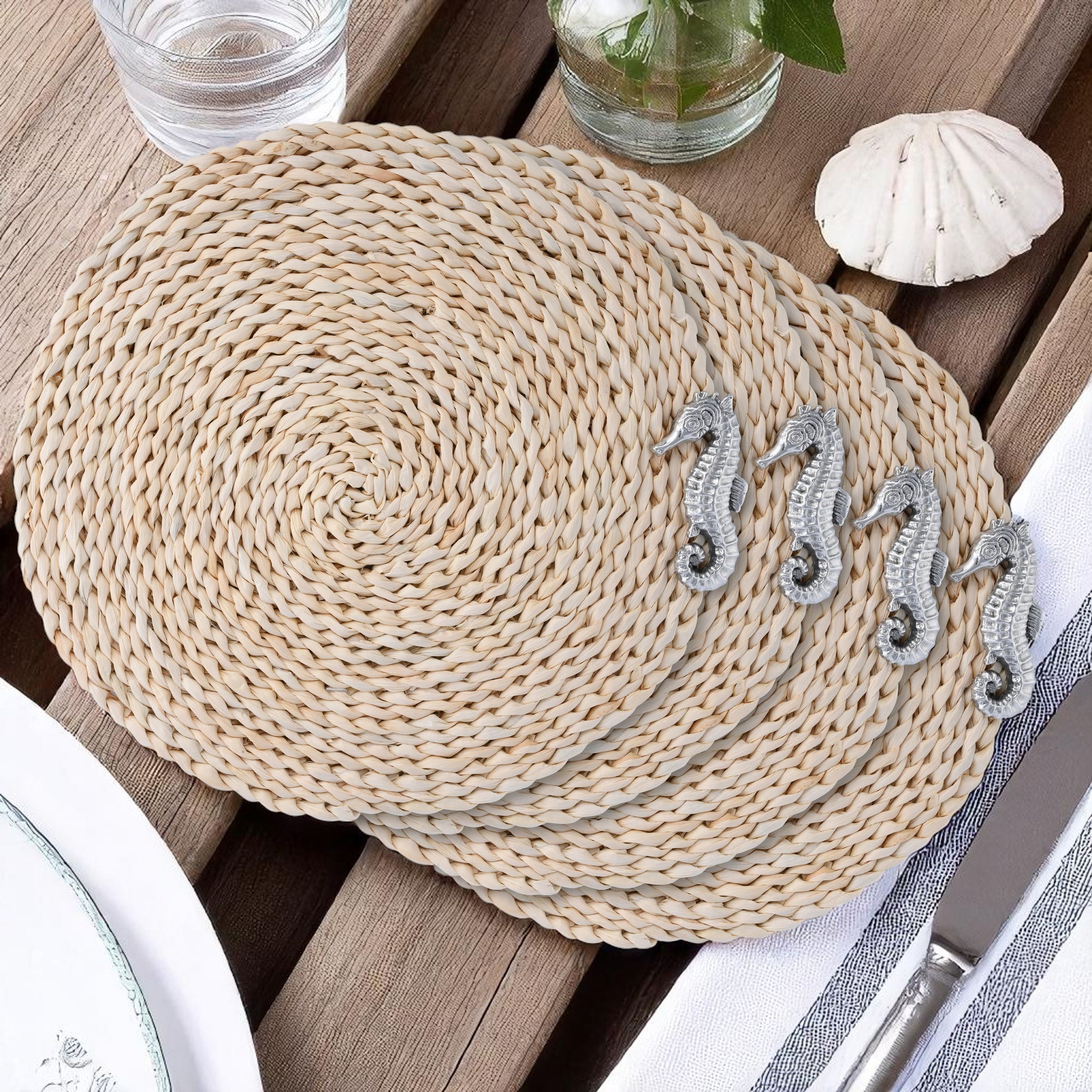 Four woven placemats adorned with seahorse accents, viewed from above on a white background, ideal for coastal decor.