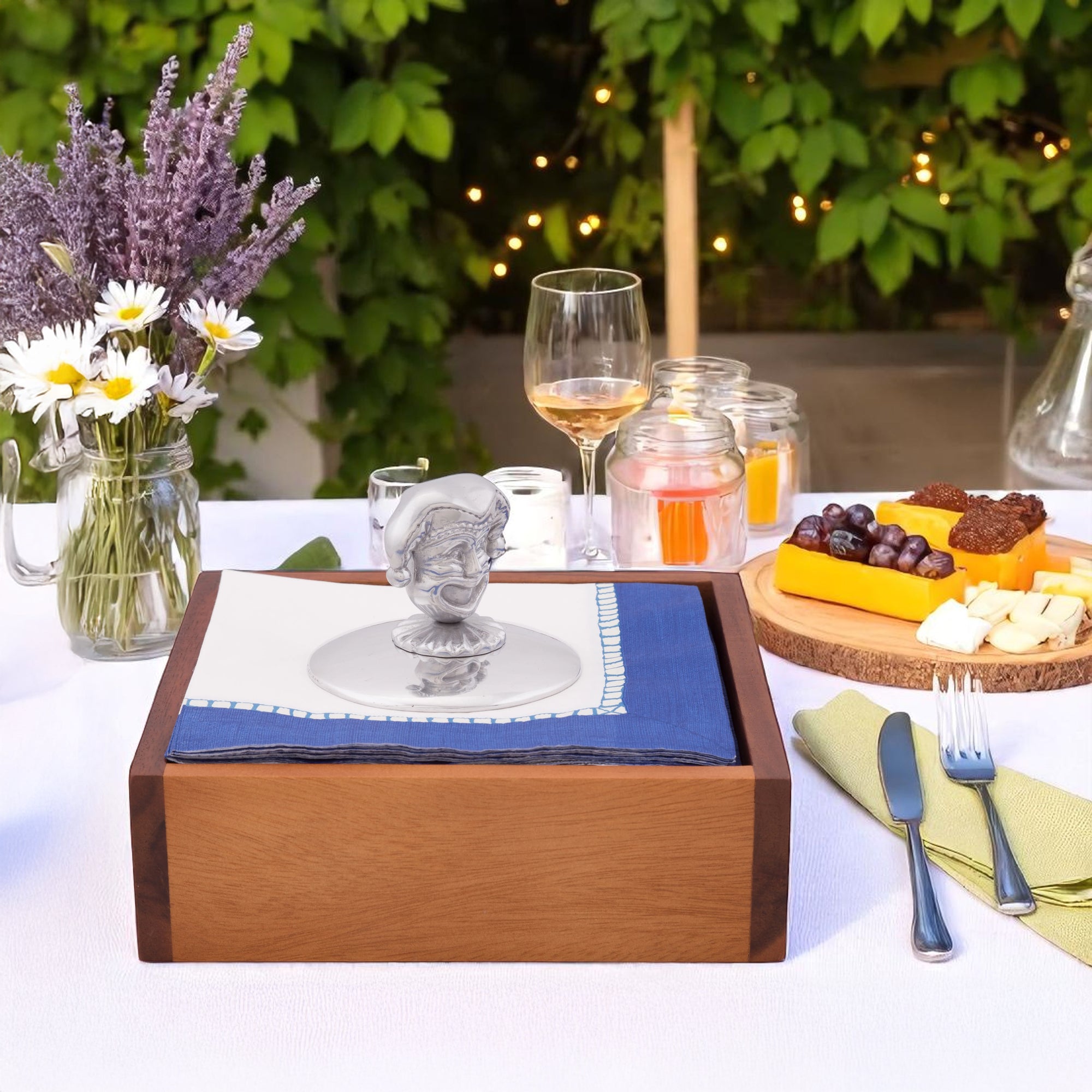 A detailed napkin weight sits atop a square wood tray, viewed from a front angle, enhancing table settings.