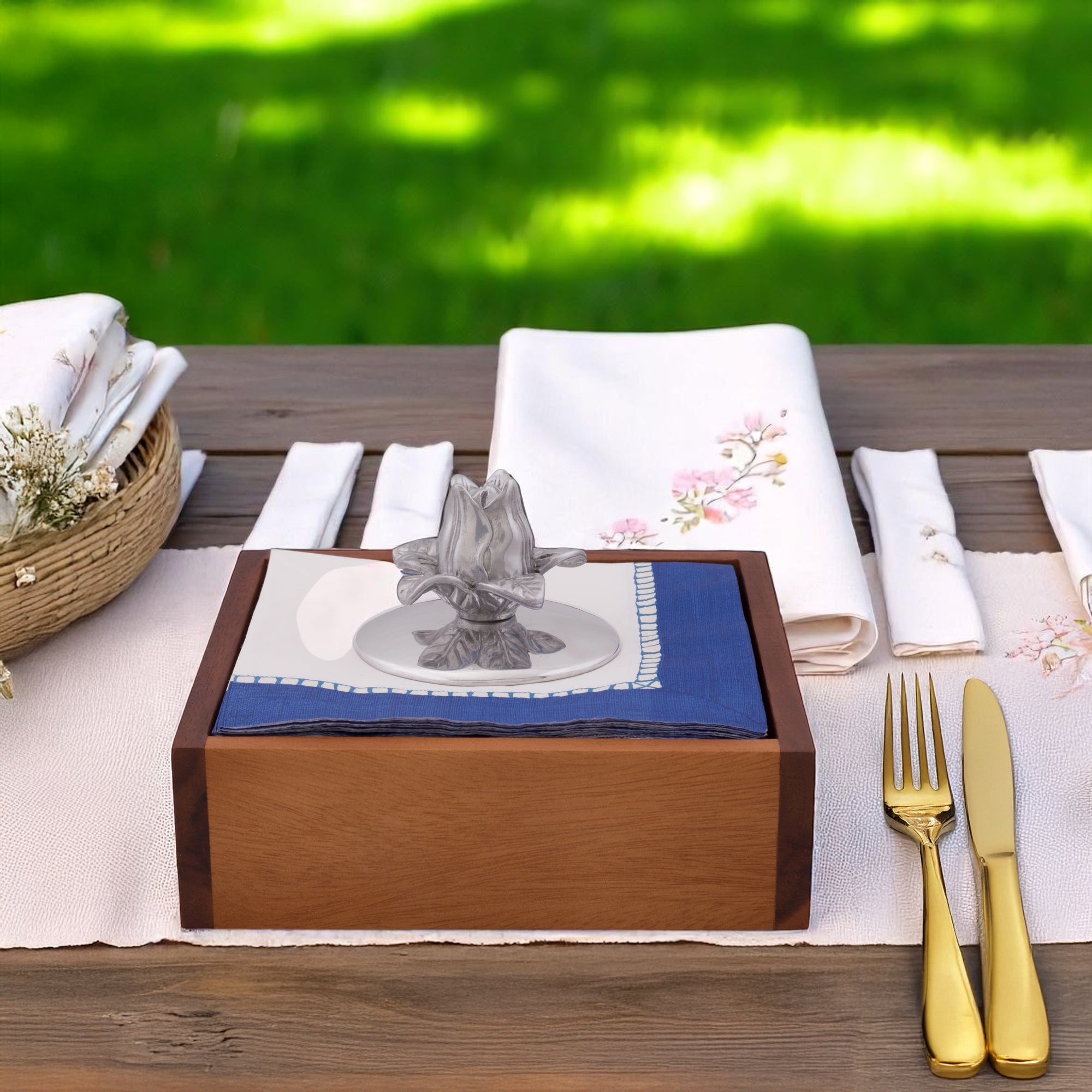 Viewed from the side, this elegant napkin weight features a floral design atop blue and white napkins in a wooden holder, ideal for luxury home accessory enthusiasts.