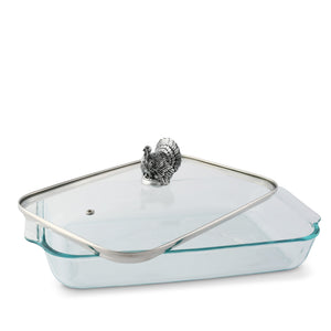 This elegant casserole server with a turkey-shaped handle viewed from a side angle makes a charming table setting centerpiece.