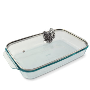 A decorative casserole server viewed from an angle showcases a detailed turkey handle, perfect for kitchen decor.