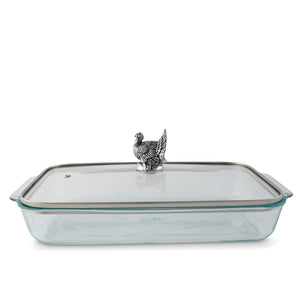 A casserole server shown in a side angle, featuring a glass dish with a silver bird handle on the lid, ideal for luxury home accessory collections.