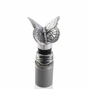 A butterfly-themed bottle stopper viewed from an angled perspective, showcasing intricate artisanal craftsmanship on a sleek wine bottle.