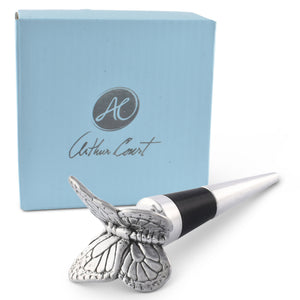 A butterfly-themed bottle stopper viewed in a side angle against a branded light blue box, showcasing artisanal craftsmanship.
