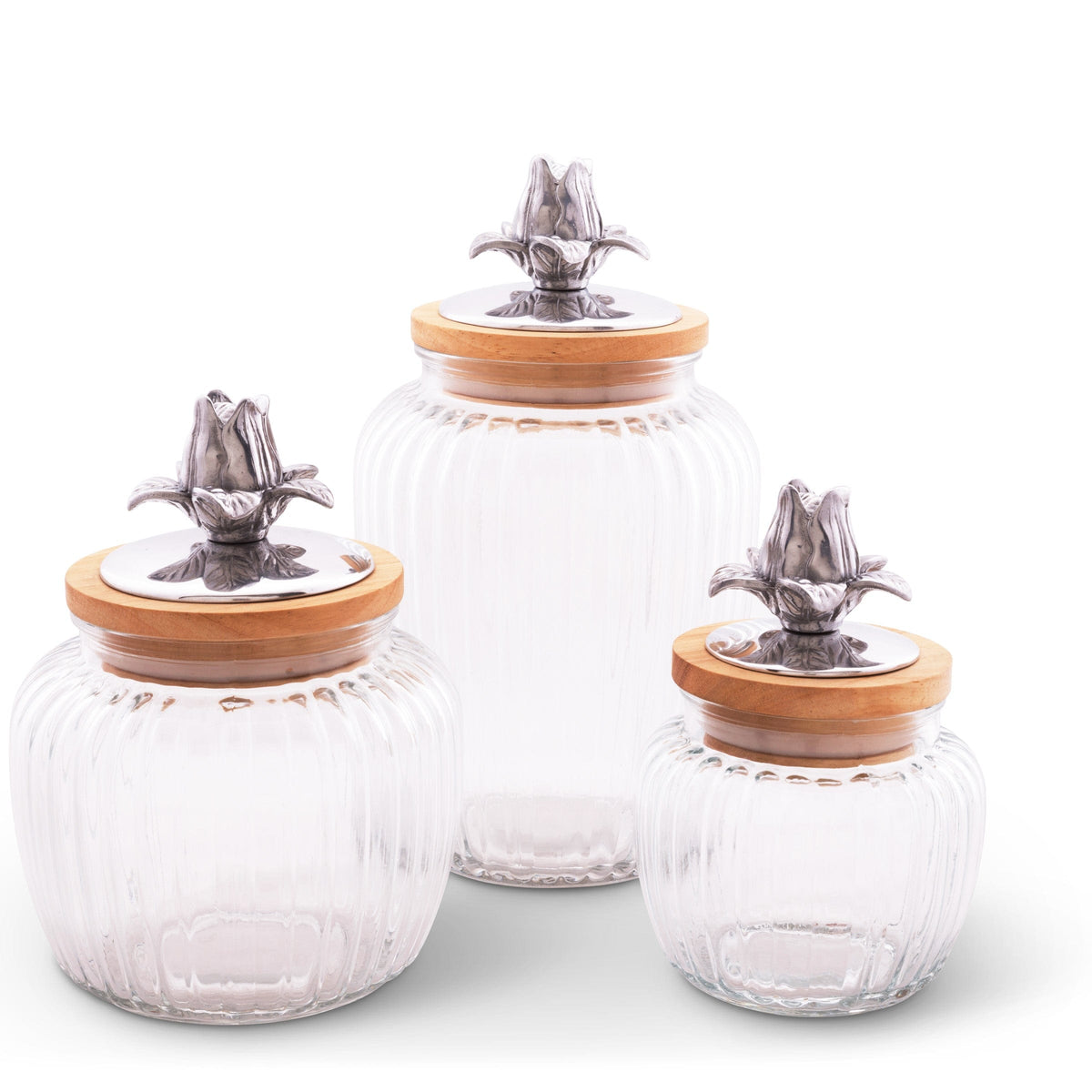 Three elegant glass canisters with ornate metal flower lids, viewed at a slight angle, perfect for kitchen decor.