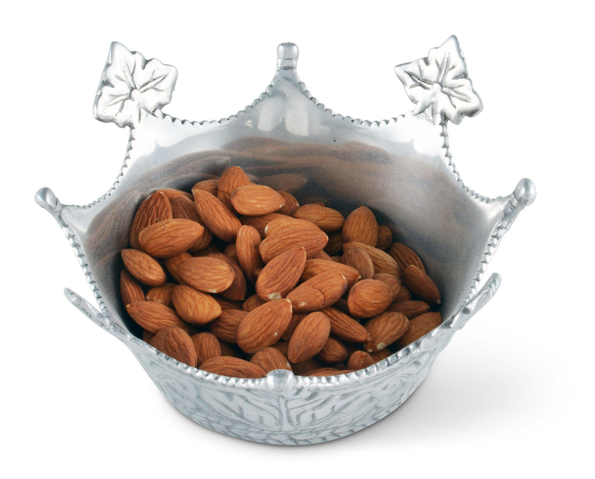 A decorative serving bowl filled with almonds, viewed from a side angle, showcasing its elegant leaf design.