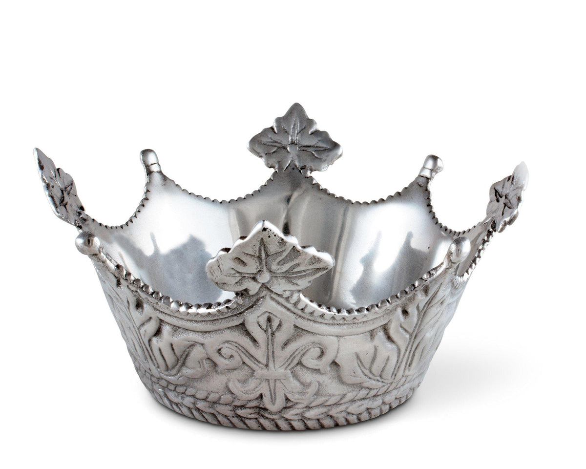 A decorative serving bowl with intricate crown detailing viewed at an angle, showcasing artisanal craftsmanship in silver.