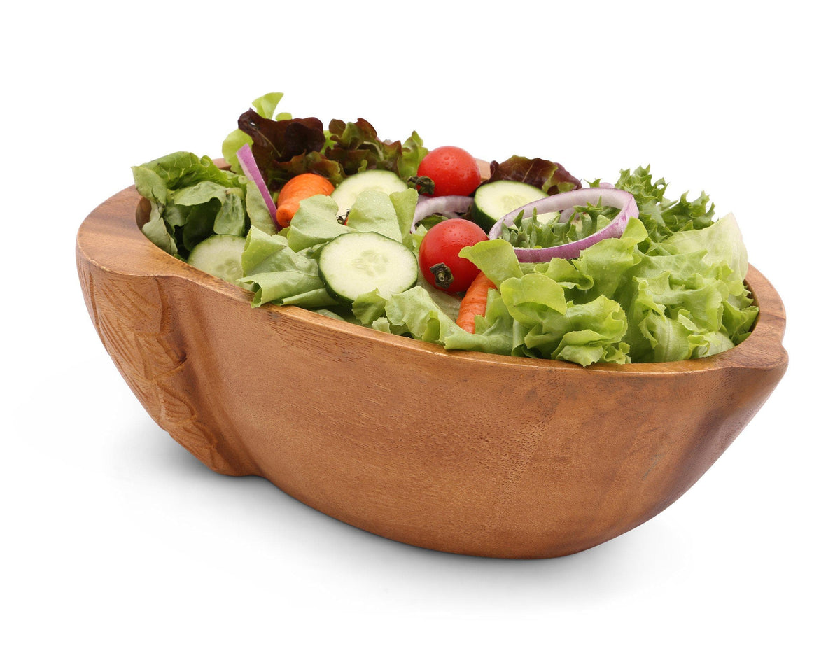 Artisanal wooden salad bowl filled with fresh greens and vegetables, viewed from a side angle highlighting its craftsmanship.