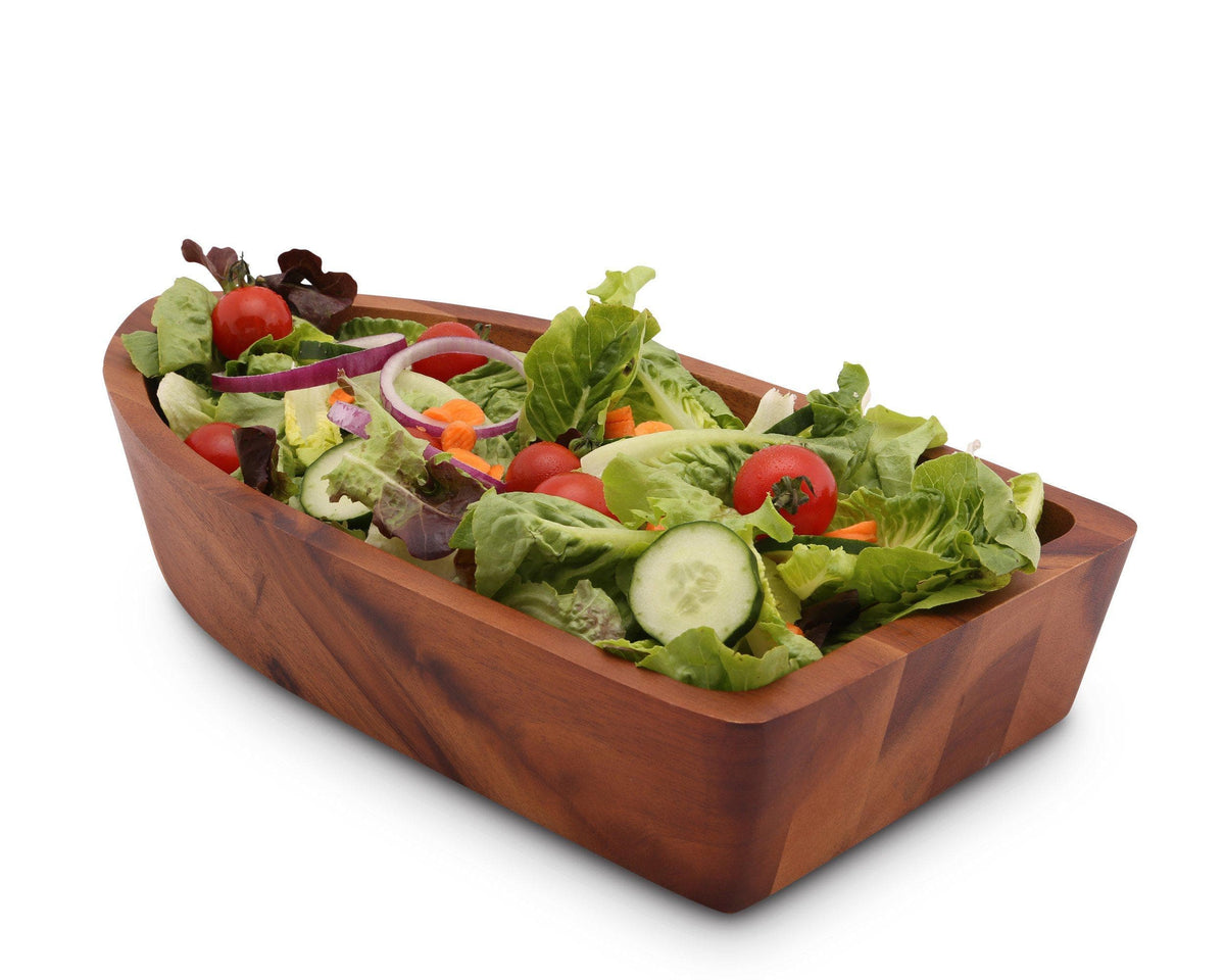 A wooden salad bowl filled with fresh greens and vegetables, seen from a side angle, perfect for kitchen decor.
