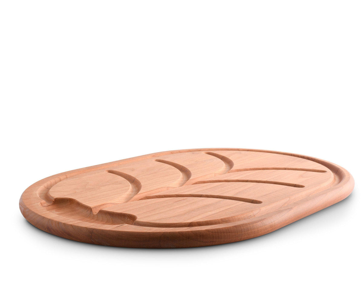 Wooden carving board with a leaf design, viewed from a slightly angled perspective, showcasing artisanal craftsmanship.