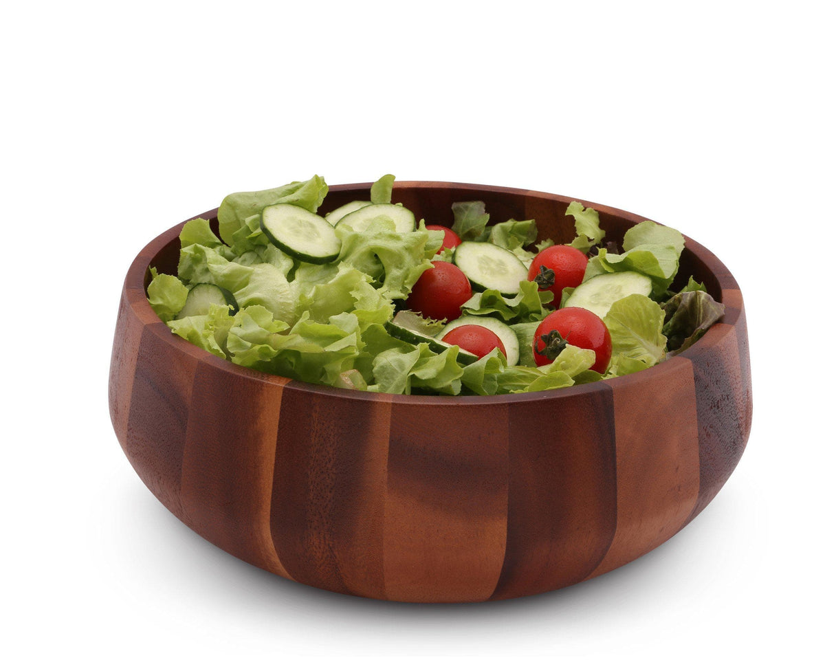 A rich wooden salad bowl filled with fresh greens and cherry tomatoes, viewed from a side angle, ideal for kitchen decor.